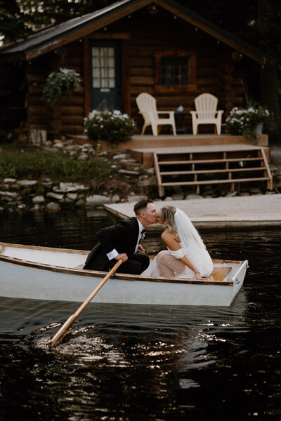 Bride and Groom kissing on a canoe at dusk