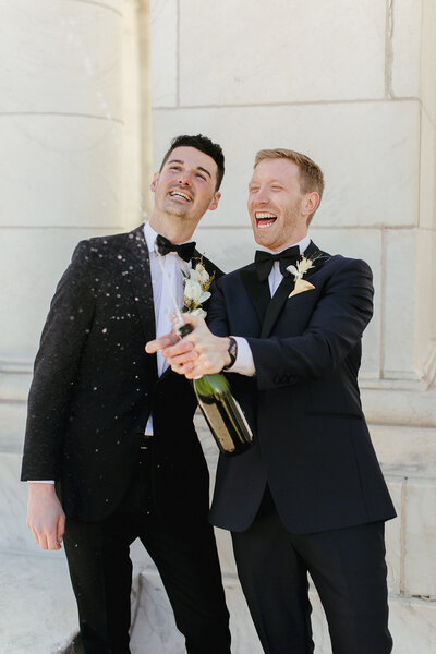Grooms pop champagne at microwedding