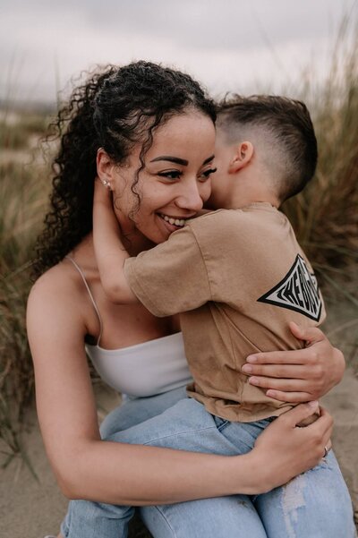 Zoontje omhelst mama tijdens familie fotoshoot op strand van Hoek van Holland