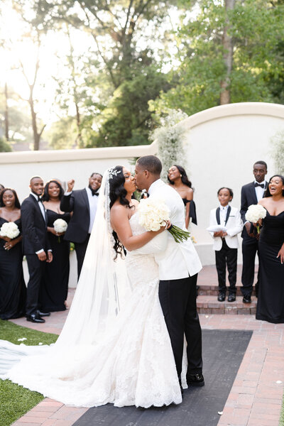 Black bride and groom looking at each other standing in the garden area of The Springs Cypress