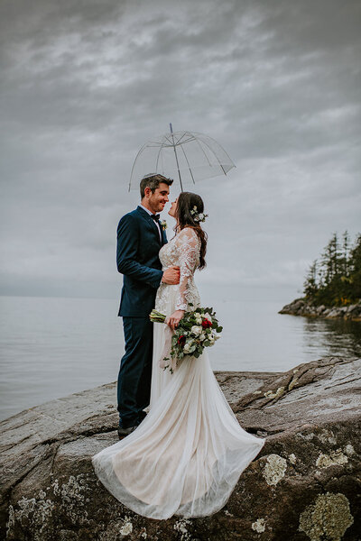 Couple kissing in the misting rain on their west coast elopement with Coastal Weddings and Events on the Sunshine Coast B.C