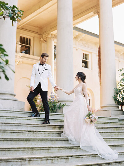 bride and groom walking up the stairs of an old  heritage house