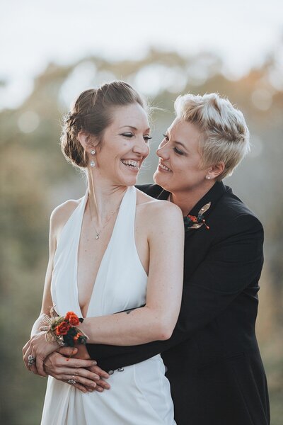 Two brides embracing