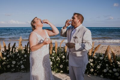 Destination wedding photographer captures couple taking shots during their Cancun Mexico resort wedding at Moon Palace