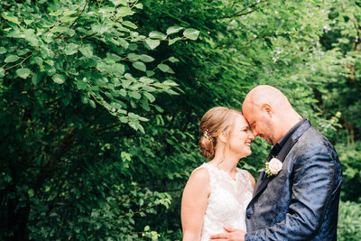 During a wedding at an outdoor wedding venue in Michigan, a couple leans in for a kiss.