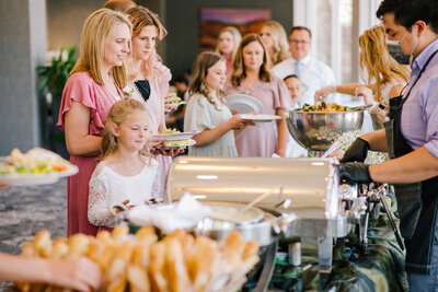 people standing in line at wedding reception buffet