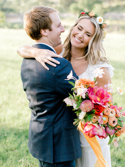 bride and groom with pink and orange bouquet