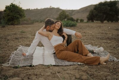couple sitting on a blanket in the grass