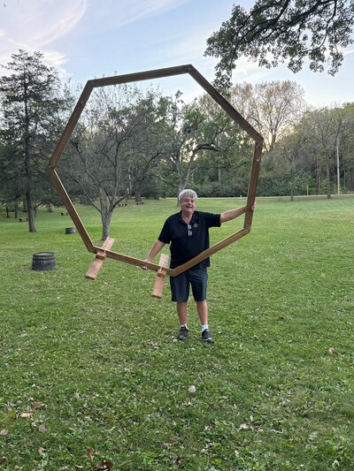 dave theco-owner lifting the wood arch at barnwood events in madison, winconsin.