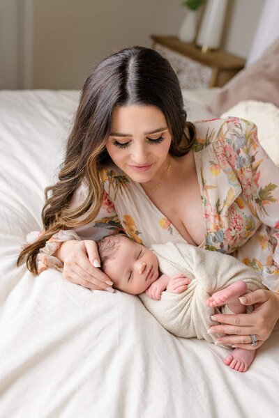 new mom lays beside her newborn son during her lifestyle newborn session in their charlotte area home
