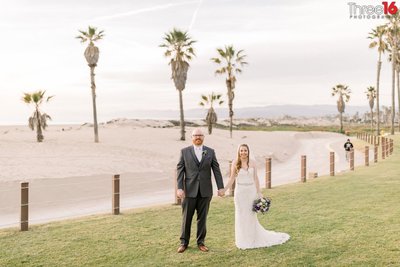 Bride and Groom pose holding hands along the beach at the Mandalay Bay Beach Resort in Oxnard