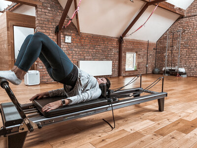 Woman in her 40's doing reformer pilates with kt chaloner