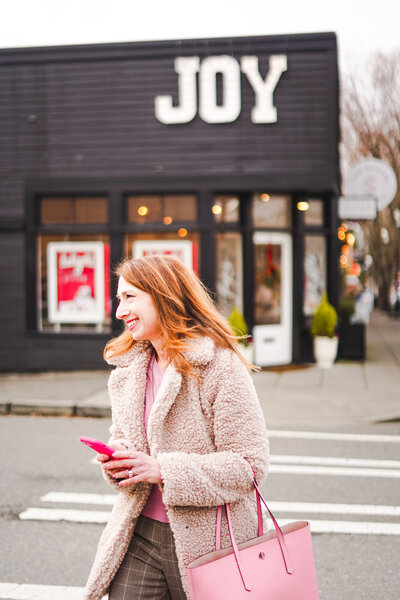 Seattle Real Estate Agent Brenda Morris smiling and walking past a historic movie theatre building in Issaquah