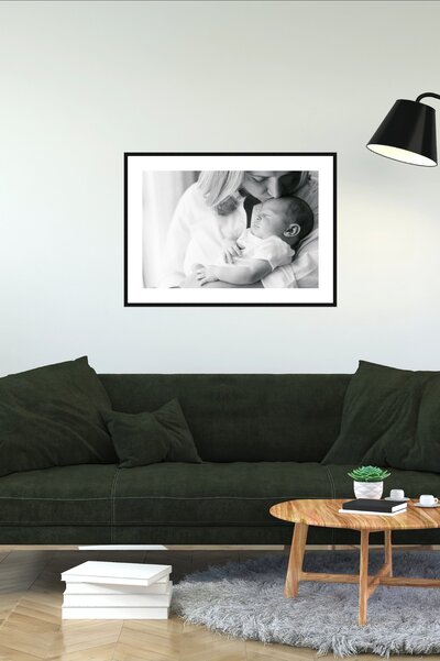 wall art from newborn photo session hangs above a green sofa