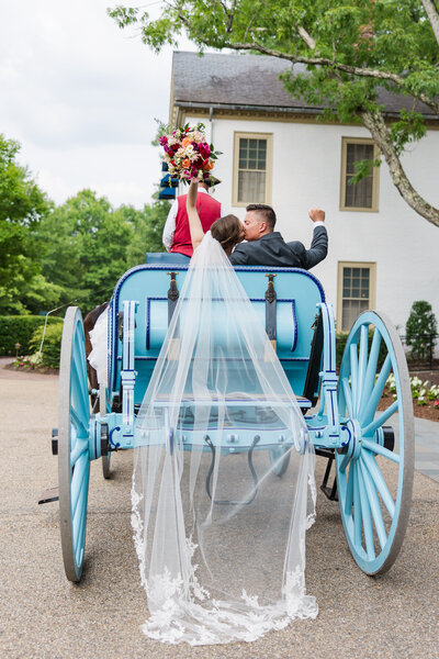 Celebrating on a fairy tale horse and carriage ride in Colonial Williamsburg after a Williamsburg Inn wedding