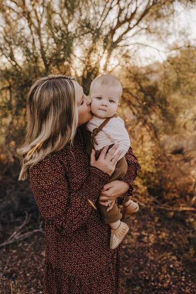mom kissing infant son at sunset desert photography session