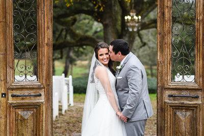 Bride and Groom kiss in front of live oak at The Venue at Southern Oaks Farm, Gulfport, MS, Mississippi Wedding