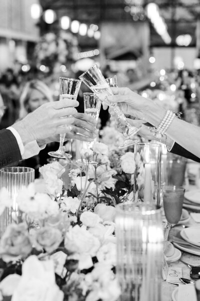 soft pink crystal glasses with floral pattern linens and plates, and yellow blue and pink florals arrangements designed by Sirpilla Soirees, Wedding Planners in Cleveland Ohio