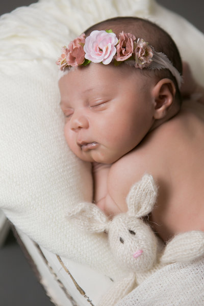 Infant with rose covered headband sleeping during the photoshoot.
