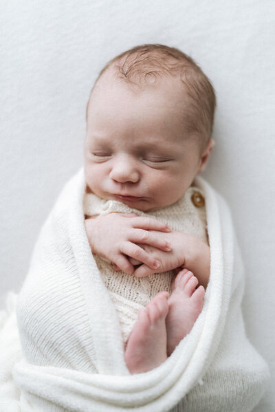 Baby swaddled up in a blanket during photoshoot in Billingshurst