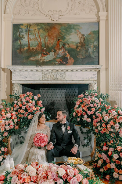 Couple sitting together surrounded by roses, Unique Melody Events & Design (New England Wedding Planners) helped