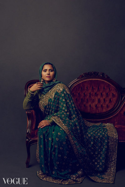Woman in a sari sitting on an antique sofa.