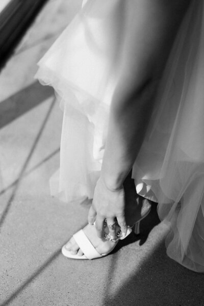 bride putting on her shoes on her wedding day