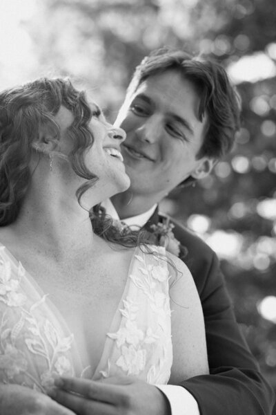 bride and groom snuggle in on sunny wedding day in Colorado