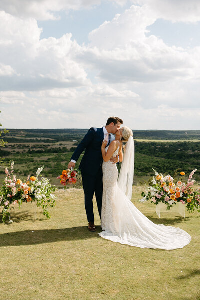 Wedding couple on bluff surrounded by flowers