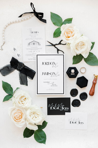 Photo of wedding details, invitation, wedding rings, and florals
