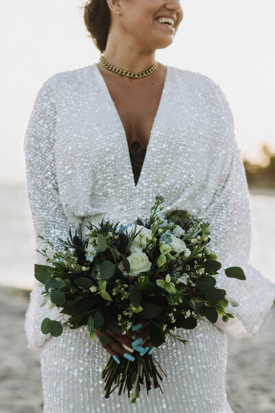 bride holding white and green floral bouquet
