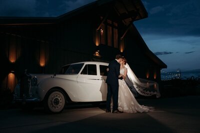 photo of bride and groom with Howe Farms vintage car