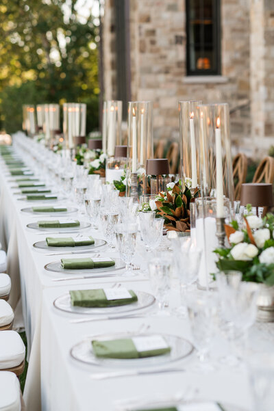 Magnolia and white taper candle centerpieces at outdoor wedding dinner in Franklin, Tennessee.