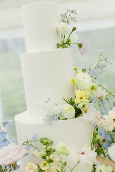 Blue and yellow wildflowers on wedding cake for Telluride estate wedding