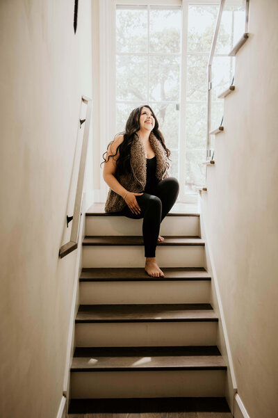 Latina smiling while sitting on stairs