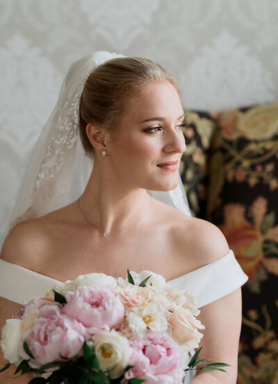 bride in her hawthorne hotel bridal suite before her wedding day. holding white and blush flowers.