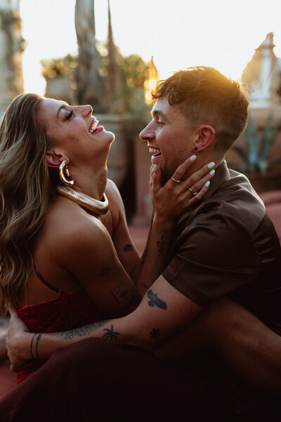 couple laugh during sunset photos