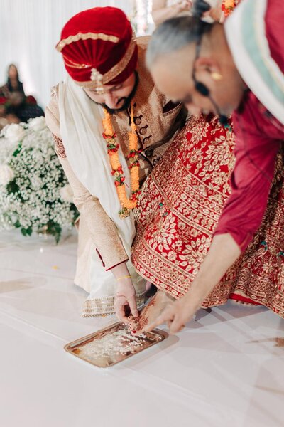 A groom performing a ritual as part of a traditional indian wedding ceremony.
