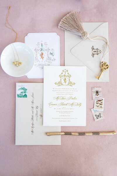 wedding invitations and jewelry beautifully styled on a pink suede captured by luxury wedding photographer