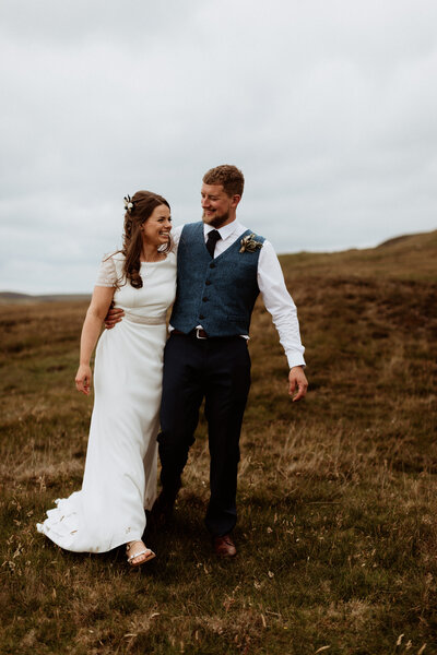 Bride and groom walk together in the heather