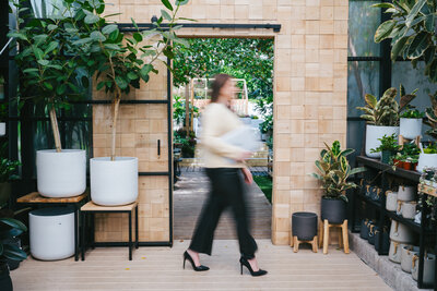 Blurred photo of a woman walking outside surrounded by plants