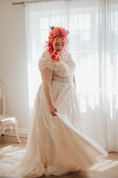 Bride standing by window in bridal suite