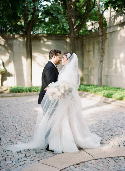 Bride and groom embracing outside at wedding venue