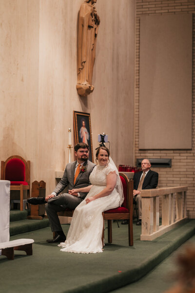 bride and groom sitting together during Catholic wedding ceremony