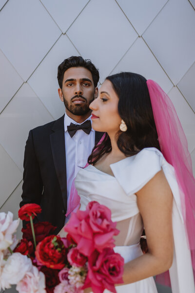 Bride stands in front of groom