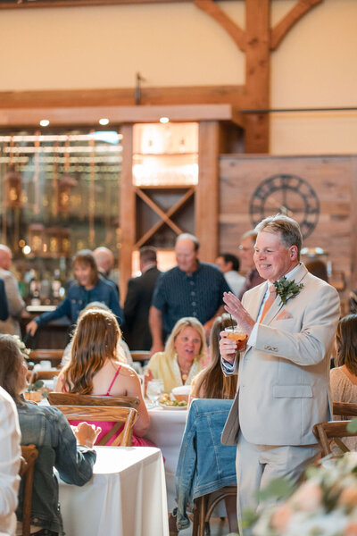 groom with guests in the barn at barnwood events in madison, winconsin.