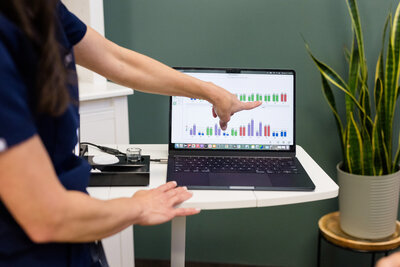 Vallie pointing to lab results on her computer