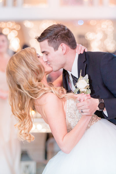 Groom dips bride for a kiss