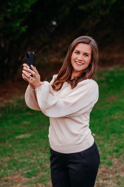 photo of Alyssa holding an iphone and smiling
