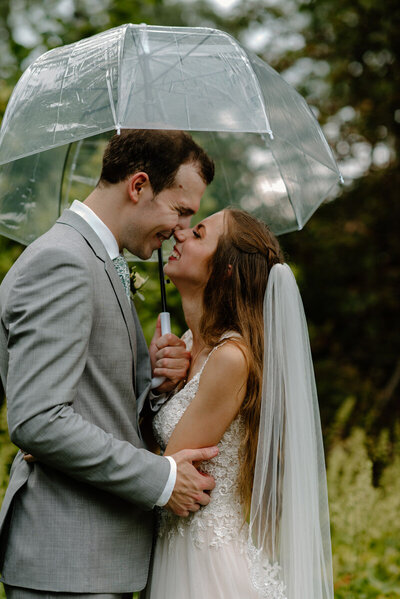 bride and groom underneath an umbrella